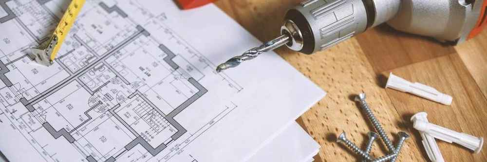 Construction tools and architectural plans for a fix and flip project